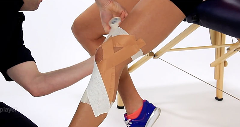 Kinesio tape application to the knee and thigh of the injured leg